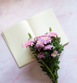 Bouquet with pink gerberas and chrysanthemums and blank notebook