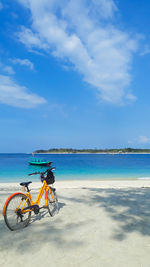 Bicycle on beach against sky