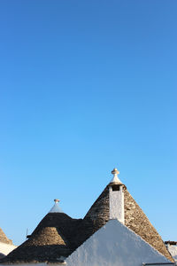 Low angle view of bird building against clear blue sky