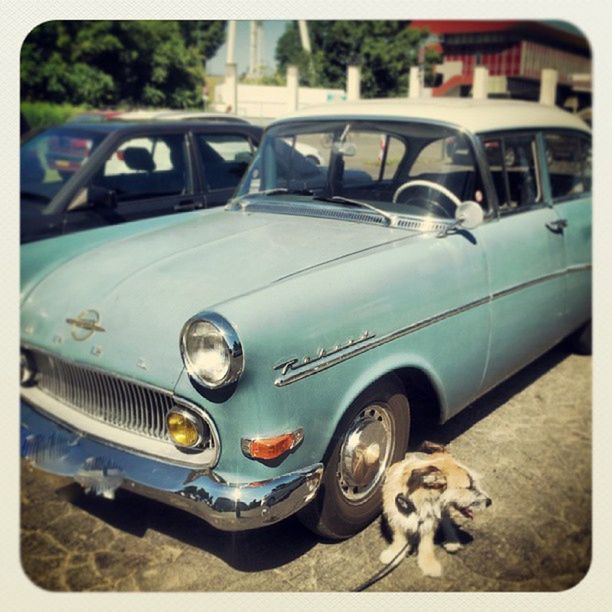 transportation, mode of transport, land vehicle, car, transfer print, stationary, auto post production filter, travel, vintage car, street, headlight, road, vehicle, part of, parked, vehicle part, day, on the move, reflection, tire