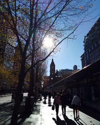 People walking on street amidst buildings in city