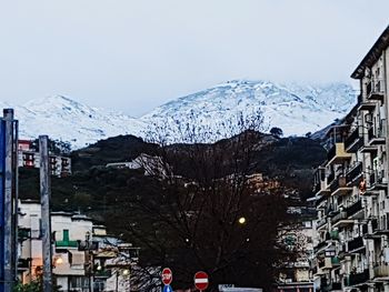 Snow covered cityscape against sky