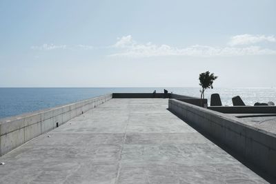 Promenade by sea against sky