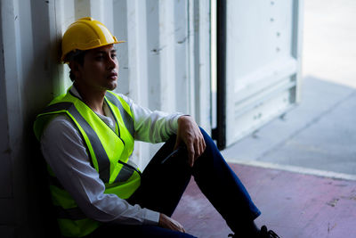 Young man looking away while standing outdoors