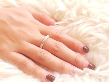 Close-up of woman hand on bed