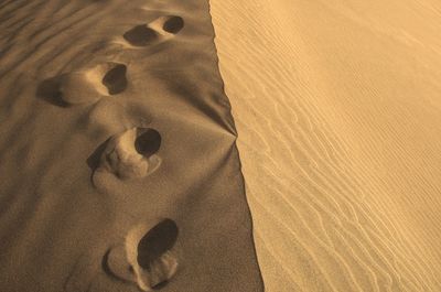 High angle view of footprints on sand at beach