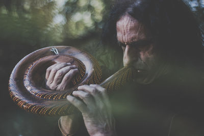 Man playing musical instrument while standing in forest