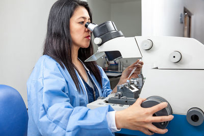 Young female scientist using an ultramicrotome to make sections for the electron microscope.