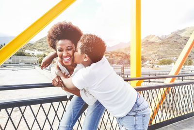 Woman kissing lesbian girlfriend on bridge in city