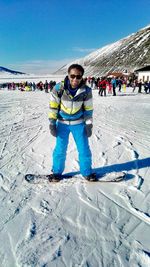 Full length portrait of smiling man skiing on snow