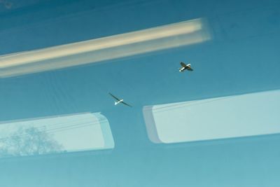Glider airplane takeoff in blue clear sky with window reflection