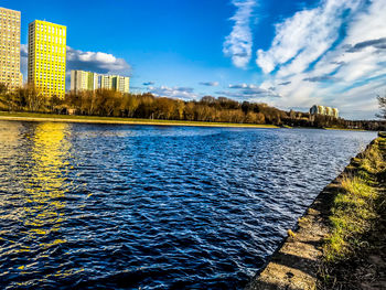 Scenic view of lake by buildings against sky