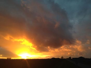 Silhouette landscape against dramatic sky during sunset