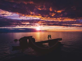 Couple watching sunset over sea