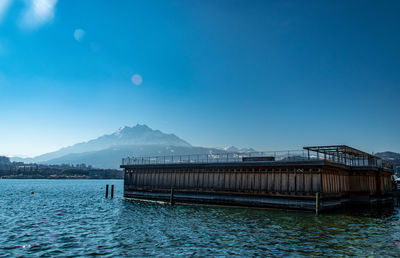 Built structure by sea against blue sky