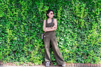 Full length of woman standing against plants outdoors