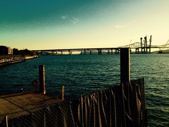 Pier over sea against sky during sunset