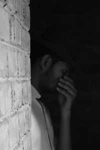 Portrait of young man looking through wall