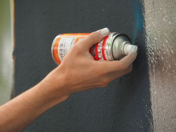 Cropped image of person painting graffiti on wall