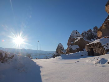 Scenic view of snowcapped mountains against blue sky on sunny day