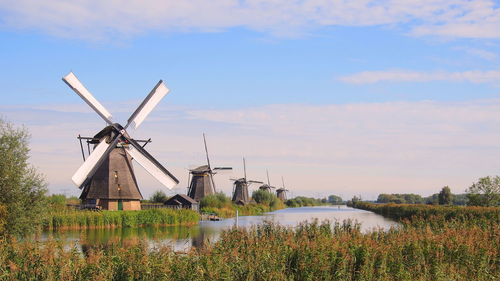 Traditional windmill on field against sky