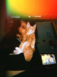 Young woman with cat sitting at home