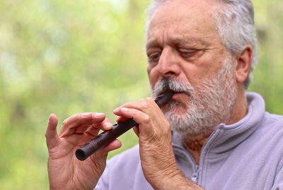 Portrait of man smoking cigarette outdoors