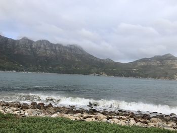 Scenic view of sea and mountains against sky