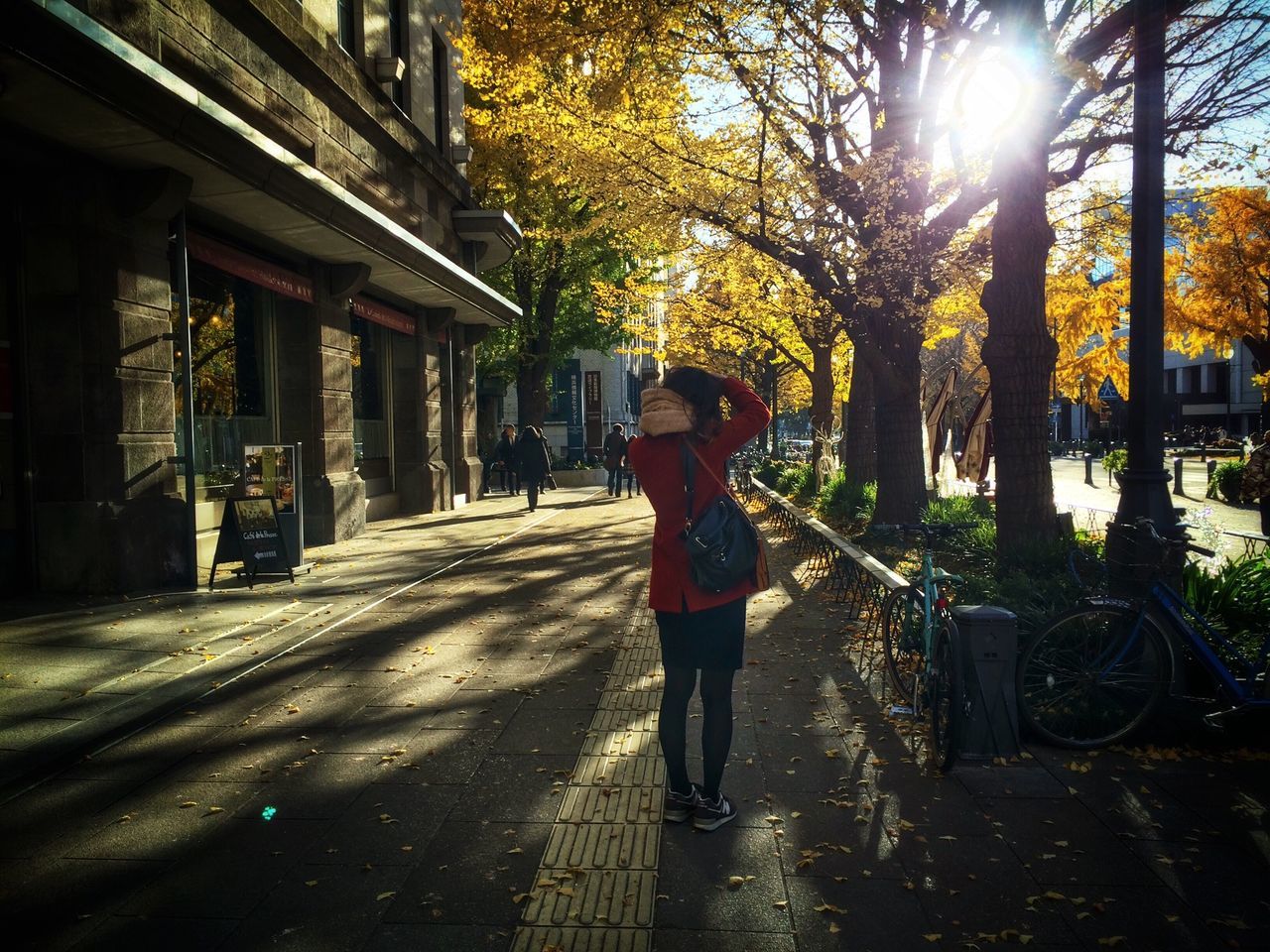 lifestyles, building exterior, full length, street, architecture, built structure, casual clothing, leisure activity, walking, transportation, tree, city, sidewalk, city life, sunlight, standing, rear view, the way forward