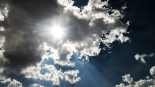 Low angle view of sun shining in sky
