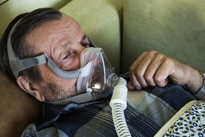 Covid-19 coronavirus infected elderly man in an oxygen mask uses mechanical ventilation