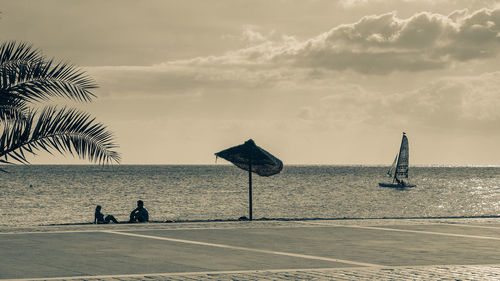 People on beach against sky