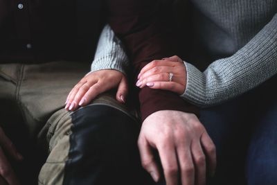 Midsection of couple holding hands