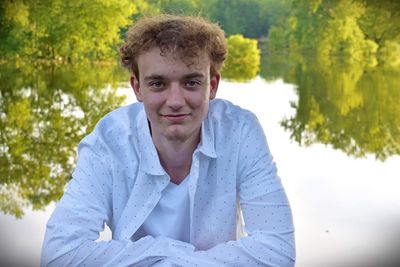 Portrait of young man against trees