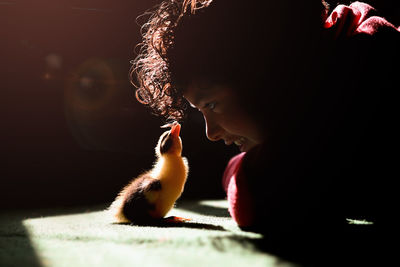 Close-up of boy with duckling