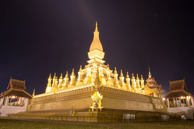 Low angle view of illuminated building against sky at night