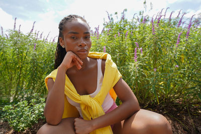 Portrait of young woman sitting on field