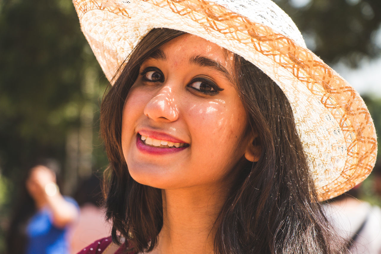 headshot, portrait, real people, one person, women, young women, young adult, focus on foreground, smiling, close-up, lifestyles, front view, leisure activity, looking at camera, adult, hat, happiness, beautiful woman, hair, long hair, hairstyle