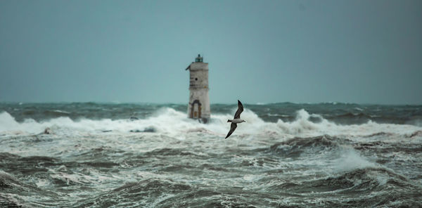 People in sea against sky