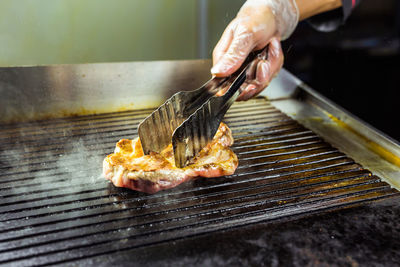 Close-up of person preparing food on barbecue grill