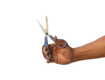 Close-up of hand holding cigarette against white background