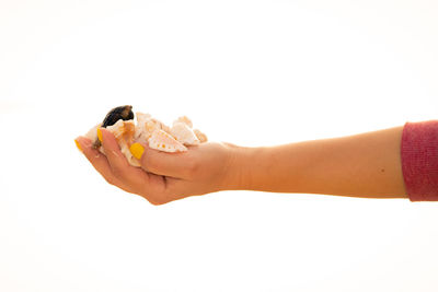 Close-up of hand holding ice cream over white background