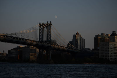 Suspension bridge over river against sky