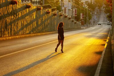 Woman walking on road in city