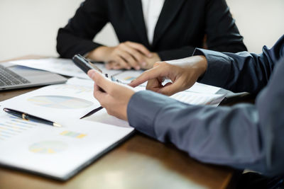 Midsection of business colleagues working on table