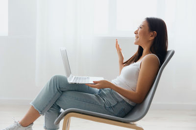 Smiling young woman using laptop