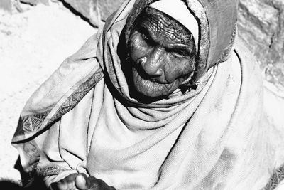 High angle view of senior woman looking away while sitting outdoors