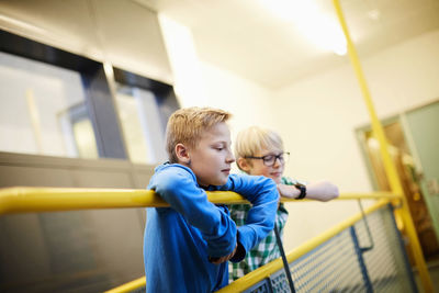 Boys leaning on raining in school building