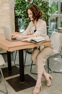 Full length of woman using mobile phone at home