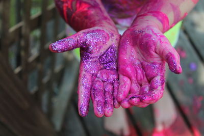 Cropped image of kid with glitters and painted hands